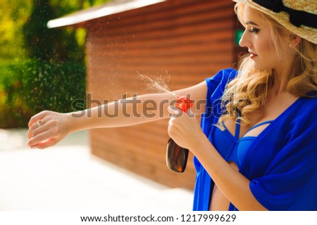 woman applying protective lotion before sunbathing in a pool