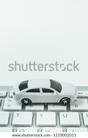 white toy car on keyboard computer close up image background.