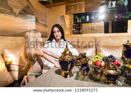 Mother and girl in a beautiful room at the table. Family has rest in the sauna