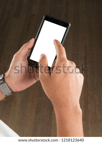 Hand holding phone with wooden floor background , blank screen 