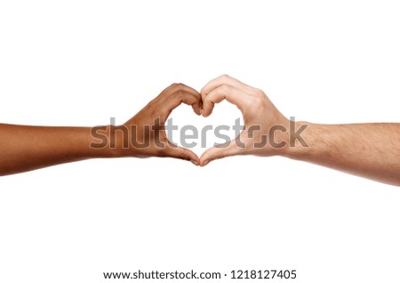 charity, love and diversity concept - close up of female and male hands of different skin color making heart shape