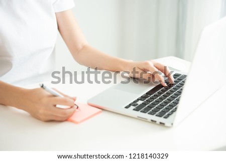 Photo hand of businesswoman working on modern loft office. woman sitting wood table and using contemporary notebook, texting message keyboard. Horizontal, lecture post it note