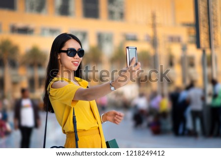 Happy Asian tourist taking selfie at Dubai mall