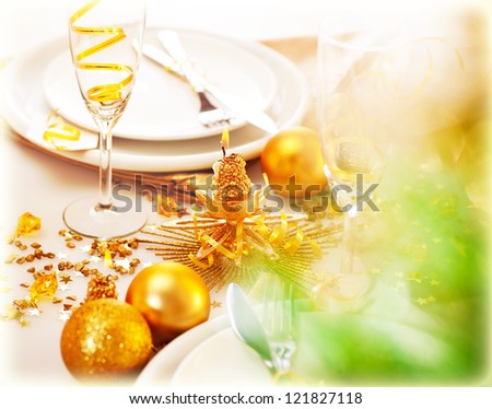 Picture of New Year table decorations, luxury festive table setting, romantic holiday dinner, white utensil adorned with golden shiny baubles, glasses for traditional Christmastime drink, champagne