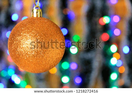Golden hanging ball, christmas decoration with blurred lights background