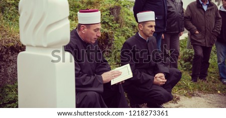 quran holy book reading by imam  on islamic funeral with white thumb stones graweyard background Royalty-Free Stock Photo #1218273361