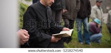 quran holy book reading by imam  on islamic funeral with white thumb stones graweyard background Royalty-Free Stock Photo #1218274540
