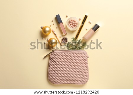 Flat lay composition with makeup products and Christmas decor on color background