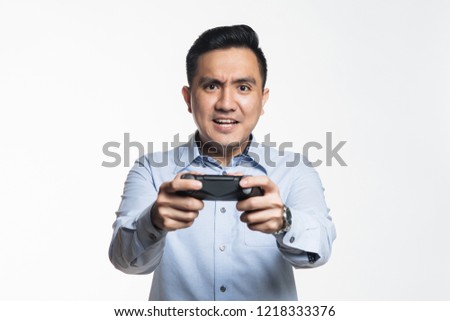 Asian man in work cloth playing console game