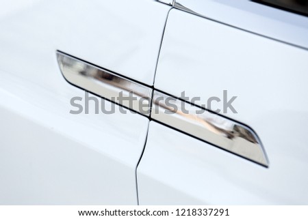 white car door handle close up, hidden retractable automatic opening mechanism chrome-plated.