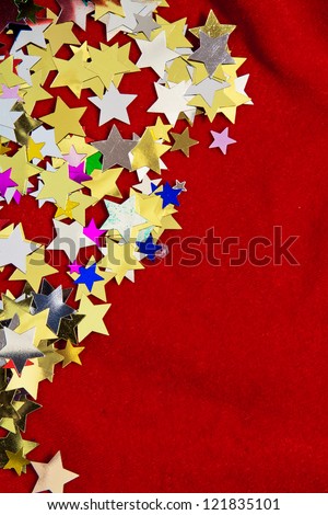 Colourful, glittering stars on gold background. Christmas wishes or birthday message. Plenty of copy space, portrait orientation.