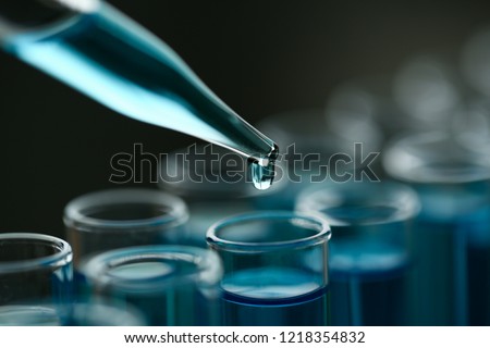 Test tube of glass overflows new liquid solution potassium blue conducts an analysis reaction takes various versions reagents using chemical pharmaceutics cancer manufacturing . Royalty-Free Stock Photo #1218354832