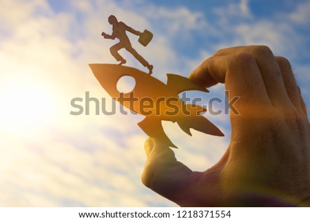 Concept start up. Silhouette of a businessman with a briefcase on a rocket holds the hand of a man. Business concept idea, success, achievement, career, work