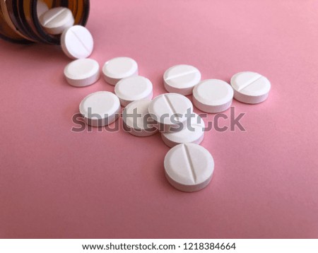 white pills on a pink background