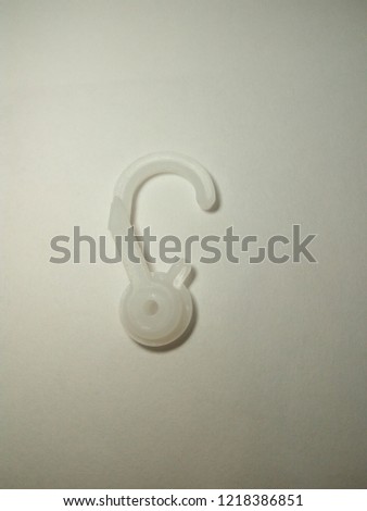 
White plastic hook for clothes or pants. Isolated on white background.