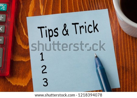 Tips and Trick written on note with pen a side, cup of coffee and calculator.

