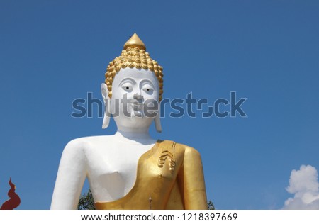 Closeup of outdoor budha statue with clear cloudy blue sky in sunny day.