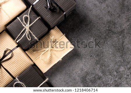 Hand made black and brown gift boxes on dark texture surface.