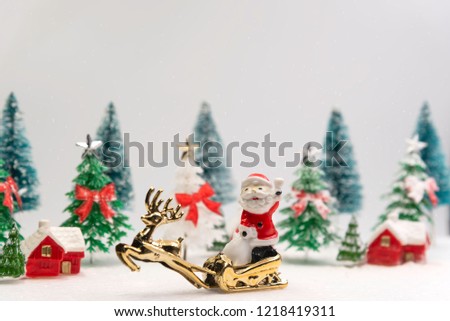 Christmas tree,santa,golden reindeer and red house in snow jungle. 