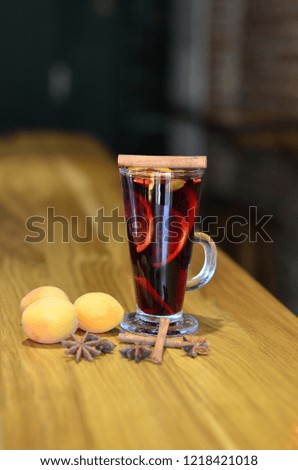 Mulled red, with fruit, cinnamon on a wooden background, winter drink