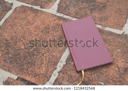 A book placed on a stone textured ground.