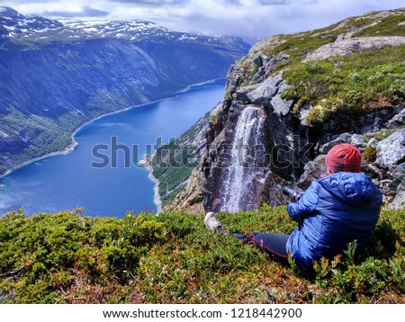 Woman takes picture of Ringedalsvatnet lake on the way to Trolltunga, Norway