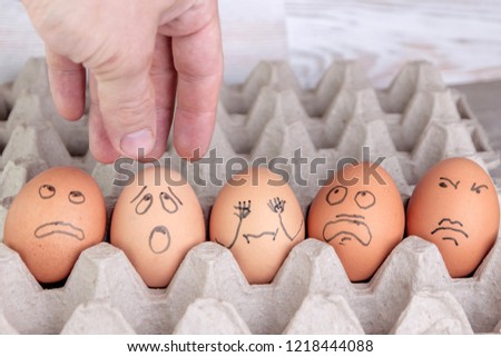 few eggs in the tray look with horror at the man's arm reaching out for them