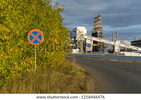 sign "stopping and parking is forbidden" on the background of a road with an industrial landscape