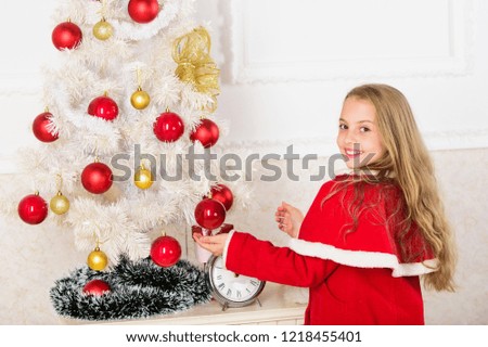 Let kid decorate christmas tree. Favorite part decorating. Getting child involved decorating. Girl long hair hold balls ornaments white interior background. How to decorate christmas tree with kid.