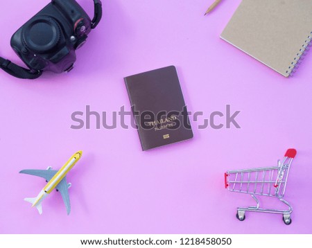 DSLR camera plane model passport shopping notebook and pencil put on pink pastel background in top view this accessories for travel and shopping