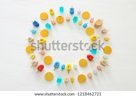 Image of jewish holiday Hanukkah with wooden dreidels colection (spinning top) and chocolate coins over white background