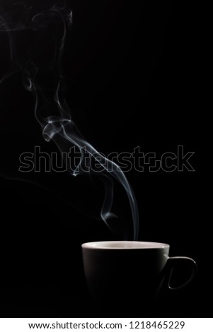 Fragrant coffee on a black background for your advertising. Smoke from hot coffee.