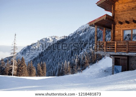 Winter vacation holiday alpine wooden house skiing relax leisure resort in the mountains covered with snow and blue sky.Dramatic cottage scene in Austrian Alps snowy panoramic landscape on a sunny day