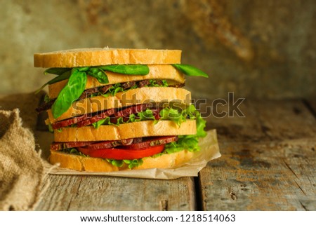 Sandwiches - bread, meat, basil, fresh leaves of lettuce on a wooden background. top view. copy space
