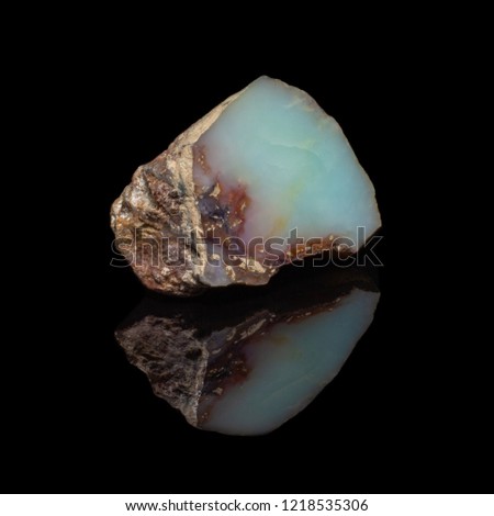 Natural polished opal stone on a black bacrground with reflection
