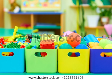 Toys in colored boxes. Cleanliness in the children's room.