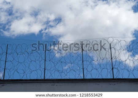 Prison wall and fence, barbed wire arround prison walls