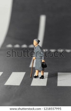 old woman crosses the zebra crossing