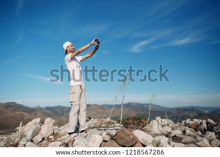 Climber on top photographing the landscape on a mobile phone