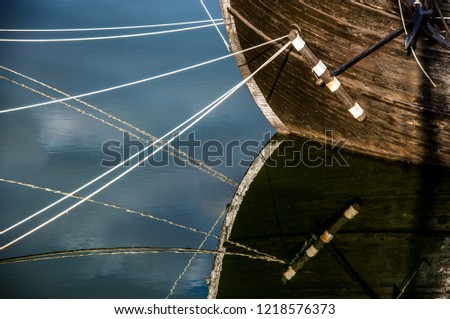 Reflections in water of an anchored boat