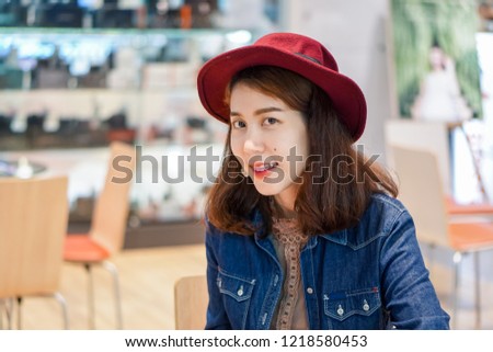 Beautiful Asian women are smiling in jeans. And wearing red hats.