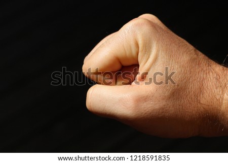 Revolution or protest concept image consisting of a clenched fist on a black background. 