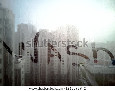 Wash - Text on Dirty window. cleaning concept - wash me words on dirty window. dirty window in the mud stains. City Background behind the glass in the blur.