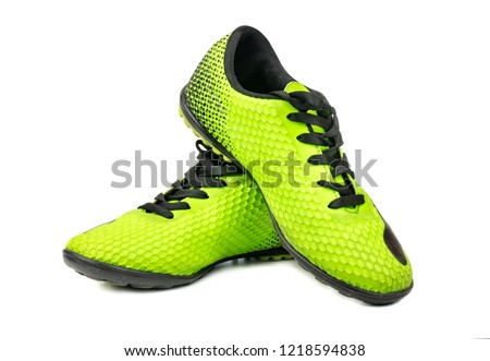 Used green football boots on white background