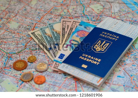 Two passports of Ukraine on the background of money and map. The concept of travel and business.