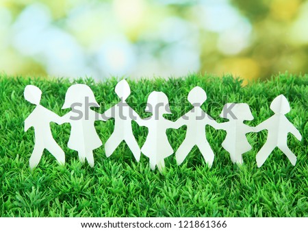 Paper people on green grass on bright background Royalty-Free Stock Photo #121861366