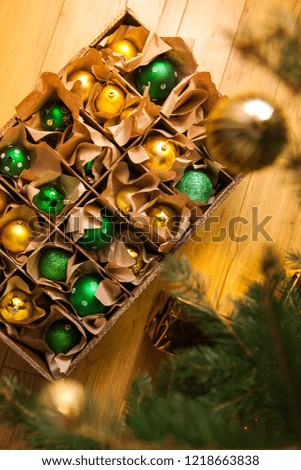 Wooden box with golden and green balls and toys for the decor. Christmas and New Year.