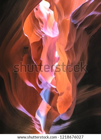 Midday rays of sunlight perpendicular the colorful caves of Antelope Canyon, east of Page in United States. Antelope Canyon is popular attraction and one of the most photographed places in the world.