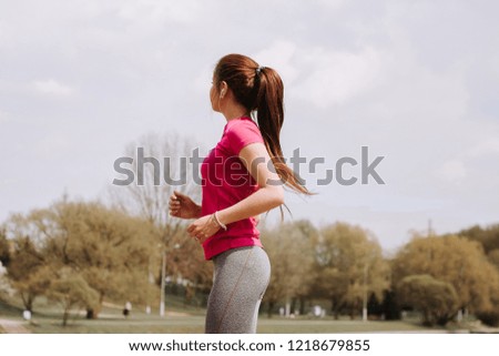 Young girl runs along the promenade in the park