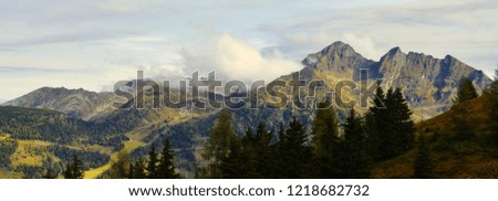 Scenic mountain landscape with mountain peaks fog,cloudy sky,rocks, trees.Mystique relaxing nature.Panoramic photo.September,Alps,Austria